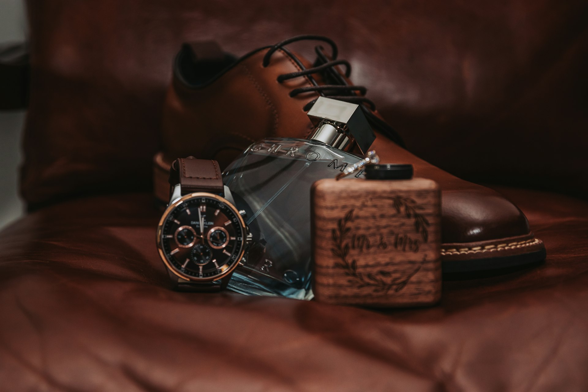 A pair of brown shoes sitting on top of a bed